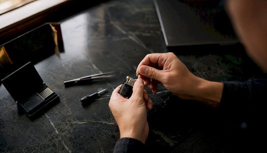 Hands replacing lighter flint with tools