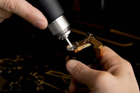 Hands refilling jet lighter with butane