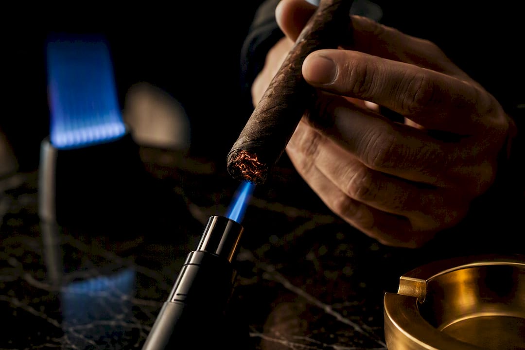 Torch flame positioned at cigar foot
