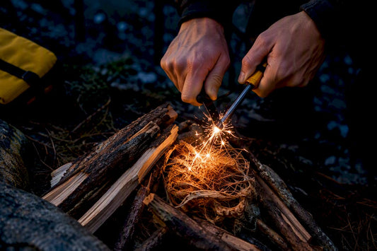 Sparks striking tinder at a forest campsite