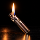 A metallic lighter with a lit flame, photographed on a dark reflective surface against a black background. — view 2