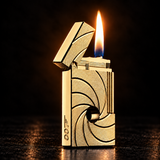 A gold-toned lighter with a spiral camera-lens-inspired pattern on the front, shown lit with a bright flame against a dark background. — view 2